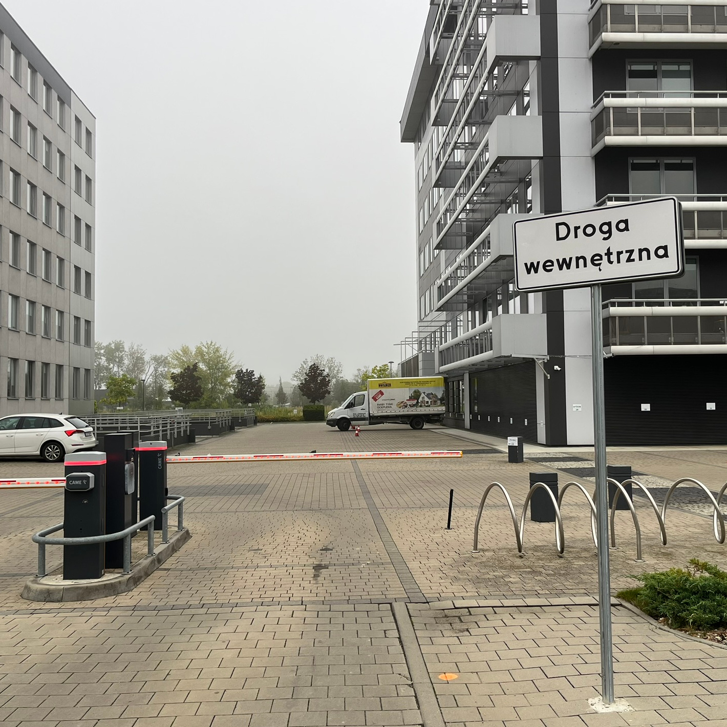 Zdjęcie parkingu przed którym stoi pojedyńczy znak 'Droga wewnętrzna'.