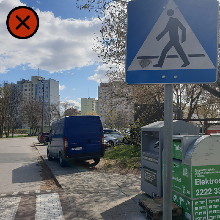 Zdjęcie pojazdu zaparkowanego za przejściem na drodze dwukierunkowej.