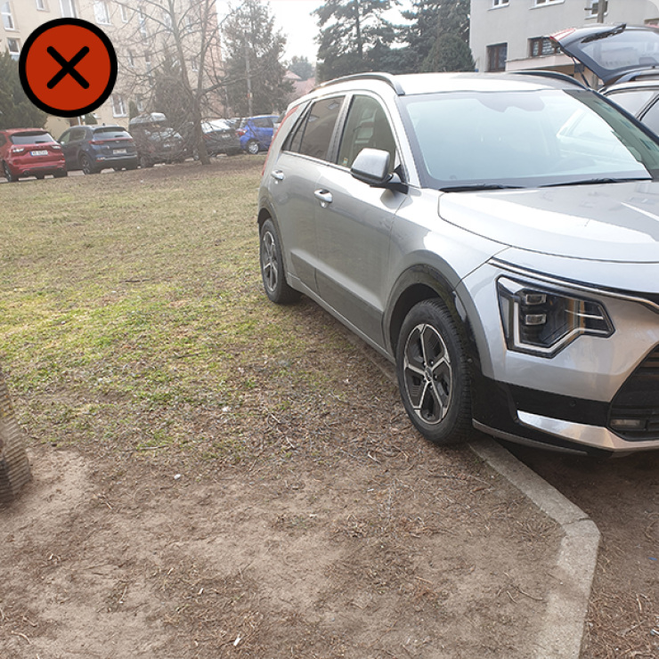 Zdjęcie pojazdu stojącego na krawędzi krawężnika, nad terenem zielonym.