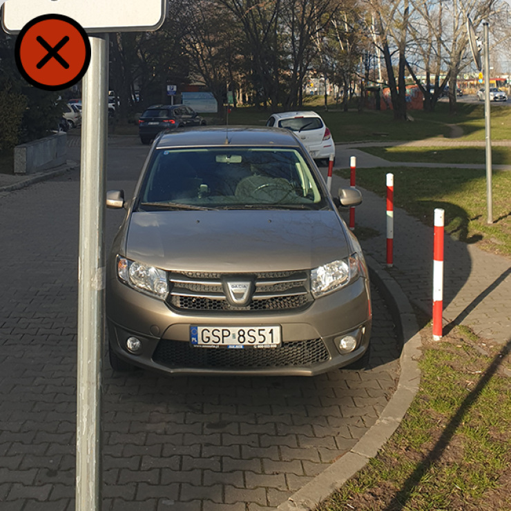 Zdjęcie pojazdu stojącego za jakimś znakiem. Na zdjęciu nie widać jaki to znak.